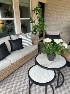 a patio with couches, tables and flowers on it