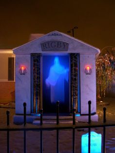 a white building with blue lights on it's sides and a black fence around it