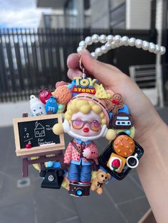 a person holding up a small ornament with various items in front of them