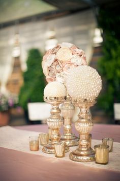 a table topped with lots of vases filled with flowers next to candles and plates