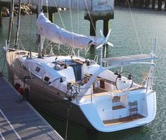 a sailboat docked at a dock with another boat in the background