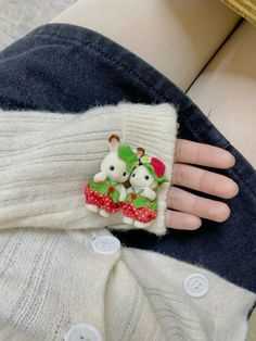 a close up of a person's hand holding a cell phone case with two stuffed animals on it