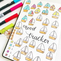 an open notebook with colorful boats and the words mood tracker written in black on it