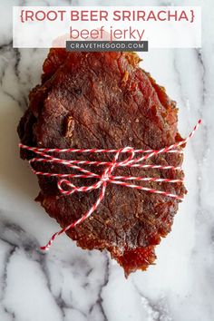 a piece of meat sitting on top of a white marble counter next to a red string