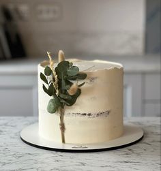 a close up of a cake on a table with leaves and flowers in the frosting