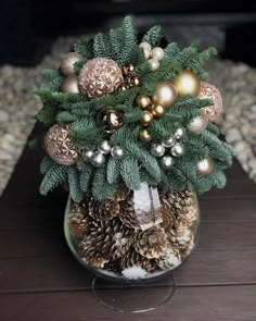 a vase filled with pine cones and ornaments