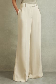 Find REISS Solene Wide Leg Split Hem Trousers on Editorialist. The Solene trousers are engineered with occasions in mind. Their smooth woven fabric features to the button closure for a clean aesthetic. Diagonal seam detailing and split hems feature to the reverse for added interest. Self-fabric button closure Side pockets Split hem Wide leg Cream Wide Leg Pants Outfits, Cream Wide Leg Trousers, Slay Fashion, Led Clothing, Cream Trousers, Leg Split, Clean Aesthetic, Wardrobe Ideas, Swimwear Brands