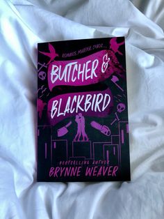 a book sitting on top of a white bed covered in sheets and pillows, with the title butcher & blackbird written above it