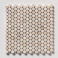 a white and beige mosaic tile with circles on the back side, arranged in rows