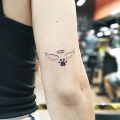 a woman's arm with a tattoo on it that has an image of a bird and paw