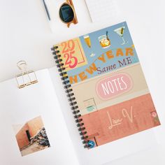 an open notebook on top of a desk next to a pen and eyeglasses