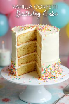 a vanilla confetti birthday cake on a white plate with sprinkles