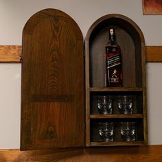 a wooden shelf with glasses and a bottle on it