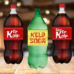 three bottles of kelp soda sitting on top of a wooden table next to each other