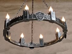 a chandelier made out of metal with candles lit inside and in the middle