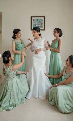 a woman in a wedding dress is surrounded by her bridesmaids