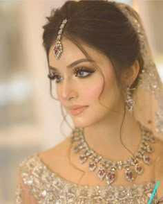 a woman in a wedding dress with jewelry on her head