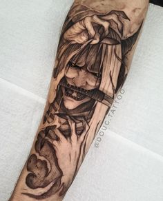 a man's arm with a black and white tattoo design on the left forearm