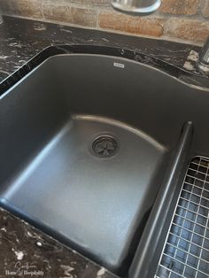 a kitchen sink with a drain in the middle and a grid on the bottom for drying dishes