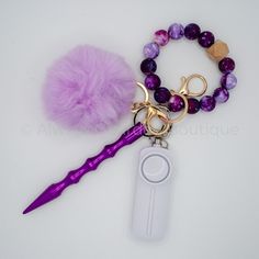 a pair of scissors, beads and a pom - pom on a white surface