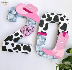 the letters are made out of paper and decorated with cowgirl accessories, including a cowboy hat