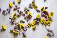 small yellow and purple flowers are scattered on a sheet of paper