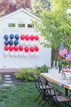 an outdoor party with red, white and blue balloons