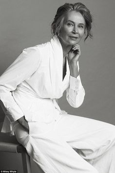 a black and white photo of a woman sitting on a chair with her hand under her chin