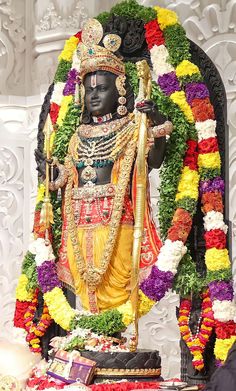 the statue is decorated with flowers and garlands