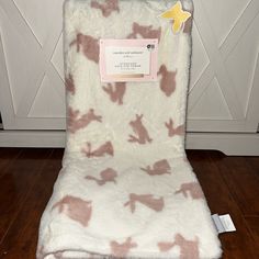 a white and pink chair with a tag on it's back that is sitting on a wooden floor