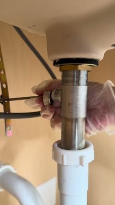 a person fixing a sink faucet in a bathroom