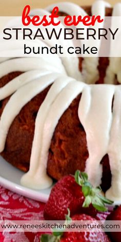 the best ever strawberry bundt cake with white icing on a plate next to strawberries