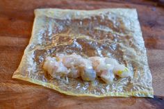 some kind of food wrapped in plastic on a wooden table