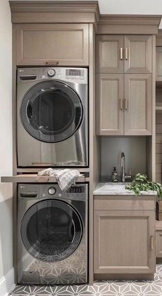 a washer and dryer in a room with wooden cupboards on the wall