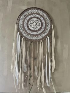 a white and brown dream catcher hanging on the wall