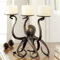 an octopus candle holder on a table with two white candles in it's tentacles