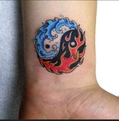 a tattoo on the wrist of a person with a blue and red fireball in the background