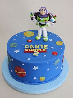 a toy story cake with buzz lightyear figure on top and stars around the base