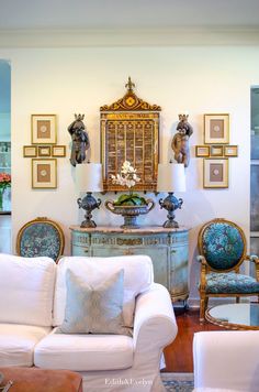 a living room filled with furniture and pictures on the wall