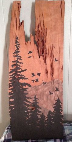 a piece of wood that has been carved into the shape of a mountain with birds flying over it