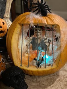 two pumpkins decorated with skeletons in a cage