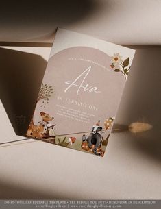 a wedding card with animals and flowers on the front is laying on top of a table