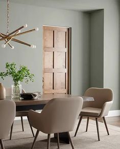 a dining room table with beige chairs and a chandelier