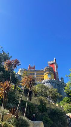 a castle on top of a hill surrounded by trees