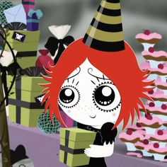 a girl with red hair wearing a witches hat and holding a box in front of cupcakes