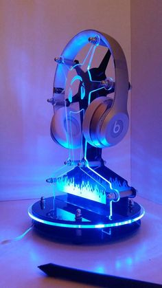 an electronic device with headphones on it is lit up in blue light and sits next to a pair of scissors