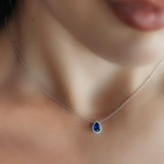 Indulge in tranquil beauty with this Pear-Shaped Blue Sapphire and Diamond Halo Necklace. It's perfect for gifting to a loved one (or yourself—no judgment here!). This piece really pops when paired with other sapphires from our Gemstone Collection. Natural Blue Sapphire: 0.80cts Natural Diamonds: 0.10ctw 18K White Gold Length: 16 Inches Luxury Sapphire Necklace With Brilliant Cut, Luxury Tanzanite Necklace With Brilliant Cut, Formal Sapphire Necklace With Brilliant Cut, Classic Blue Diamond Necklace With 17 Jewels, Exquisite Blue Teardrop Jewelry, Blue Oval Diamond Necklace Fine Jewelry, Blue Oval Diamond Necklace In Fine Jewelry Style, Teardrop Sapphire Necklace In Fine Jewelry Style, Elegant Blue Diamond Pendant Necklace