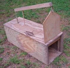 an old wooden box sitting in the grass with a handle on it's side