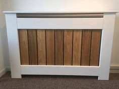 a white headboard with wooden slats on the top and bottom panel, in front of a wall