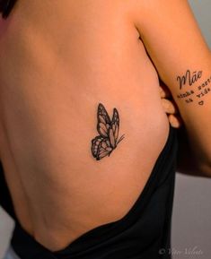 a woman with a butterfly tattoo on her left side shoulder and right arm behind her back